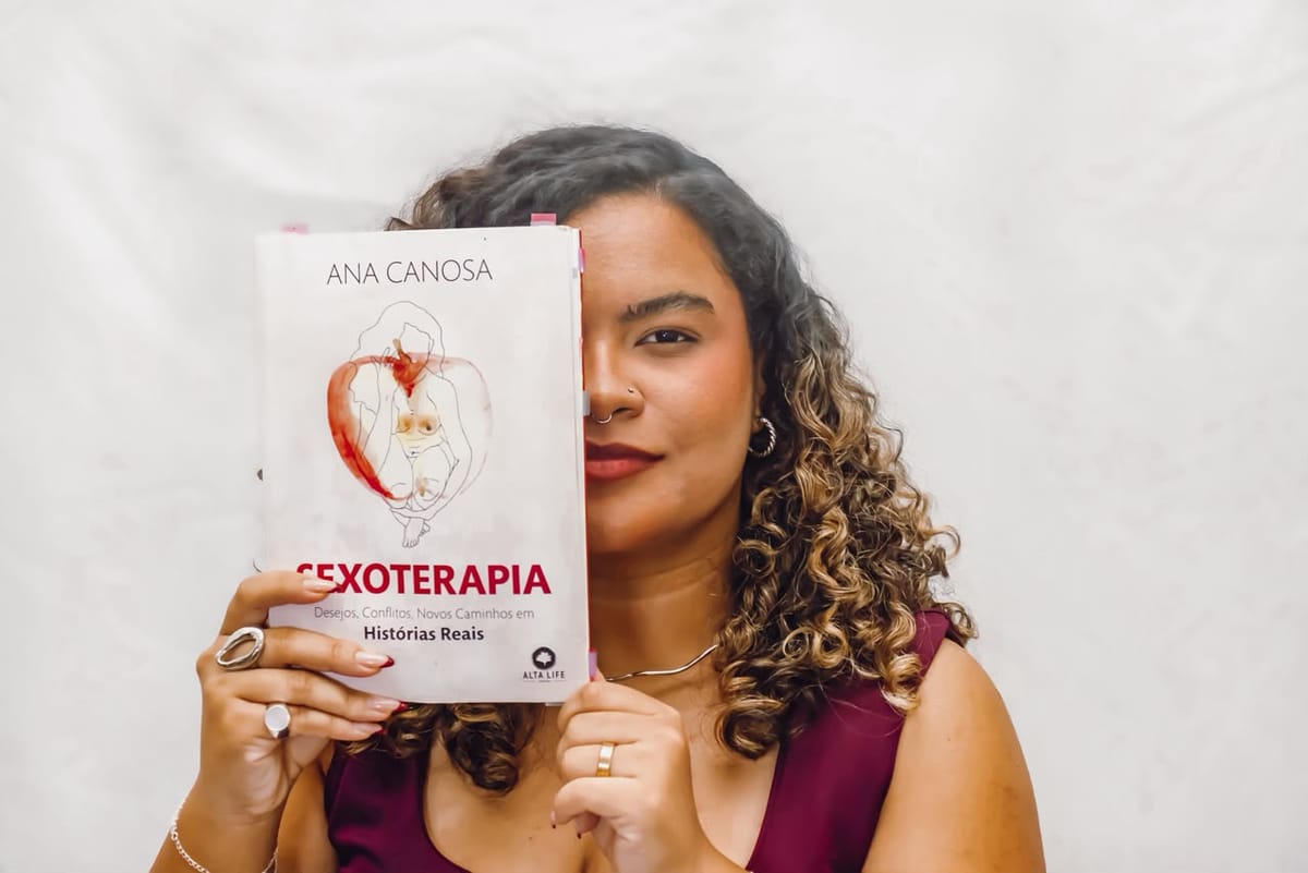 Ingrid Sena segurando o livro Sexoterapia, de Ana Canosa, cobrindo metade do rosto
